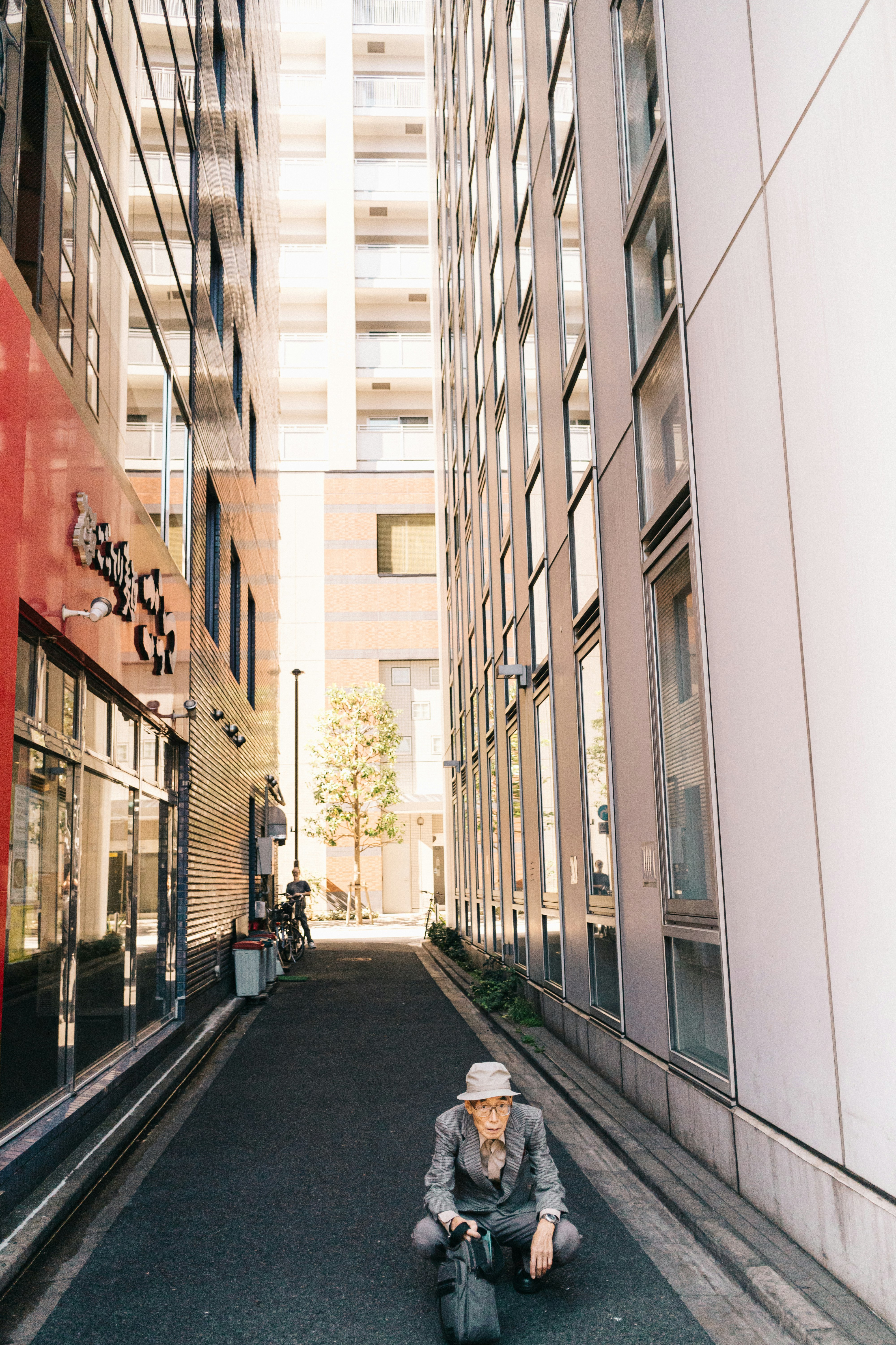 man sitting near white building